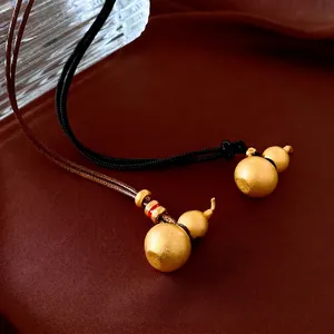 Matte gold gourd pendants on woven ropes with elegant red and white beads