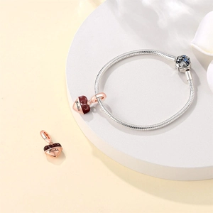 Macro detail of S925 silver snake chain bracelet with heart chocolate charms