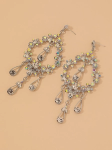 Detailed view of silver drop earrings with floral vine design and sparkling crystals