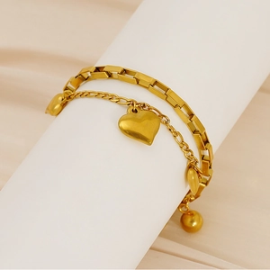 Vue détaillée du bracelet doré double épaisseur avec pendentif cœur et perles