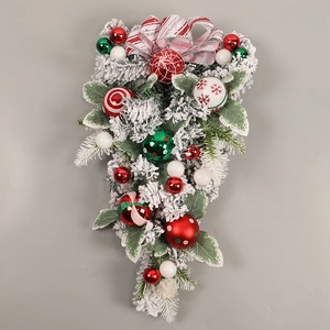 Detail of flocked Christmas teardrop swag with red and green painted ornaments and bow