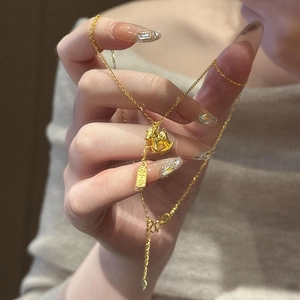 Detailed close-up of 24K gold plated rocking horse pendant and engraved tag on necklace