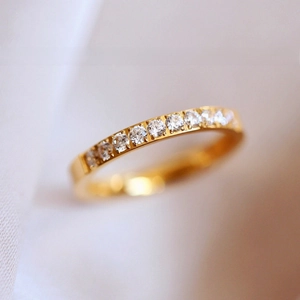 Macro shot of gold-plated titanium ring featuring a half-circle of sparkling pavé crystals