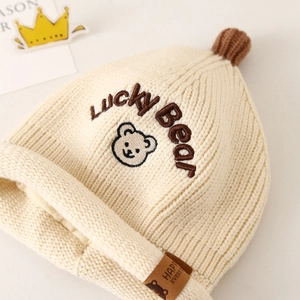 Detailed close-up of knitted baby bear hat with Lucky Bear embroidery and warm lining