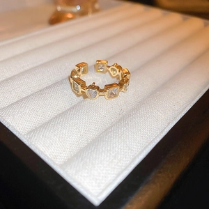 Detailed shot of gold-plated dragon ring with assorted zircon stones on white silk base
