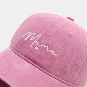 Close-up of white Mama embroidery on pink washed cotton fabric of a baseball cap