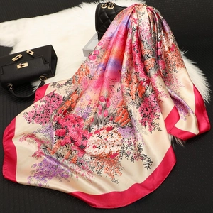 Detail of floral satin square scarf with magenta border on plush carpet background