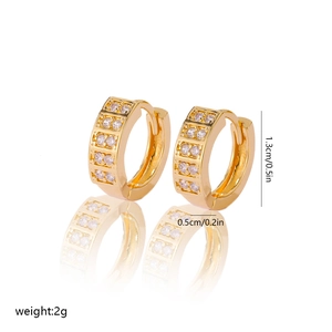 Detail shot of gold huggie earrings with dimensions 1.3cm height and 0.5cm width