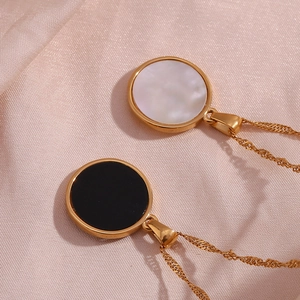 Macro shot of gold plated sun and moon round pendants on a silk texture background