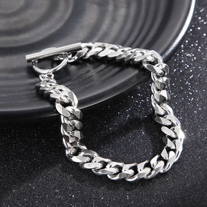 Detail of silver stainless steel Cuban chain bracelet with OT toggle clasp on black disc