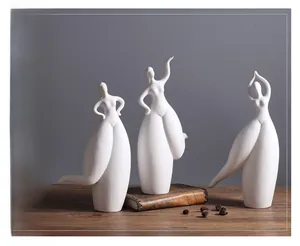 Three elegant white ceramic female art sculptures on a rustic wood table with a dark background