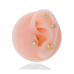 Detailed view of G23 titanium gold ear studs with zircon butterfly and flower designs