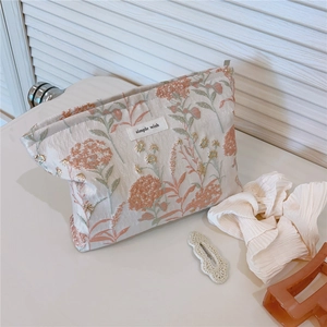 Detailed texture of floral jacquard canvas makeup bag with simple wish label and zipper