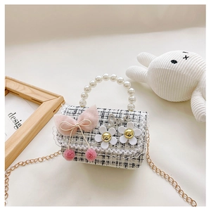 Close-up of tweed plaid children handbag with pearl handle and pink satin bow detail