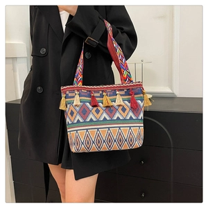 Close-up of ethnic tote bag featuring colorful geometric patterns and decorative fringe detail