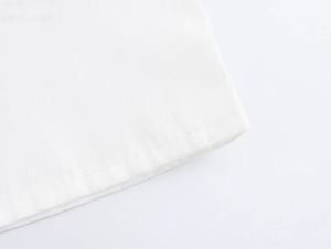 Detailed close-up of white canvas bag bottom showing premium stitching and fabric texture