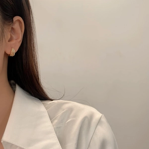 Macro shot of gold-plated triple layer hoop earrings with sparkling white crystals