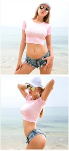 Dettaglio di pantaloncini in denim sfrangiati e crop top rosa per abbigliamento mare
