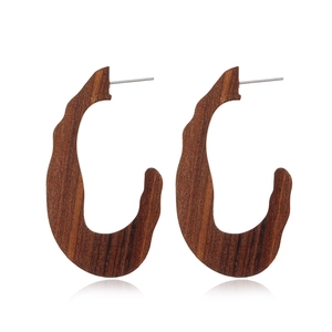 Close-up of vintage U-shaped hollow wooden earrings with polished dark brown finish