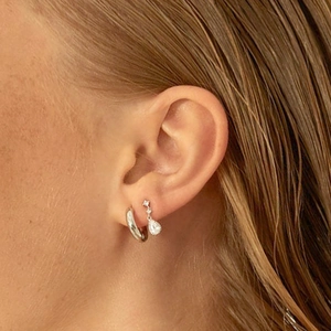 Close-up of elegant S925 silver needle drop earrings with crystals worn by a model