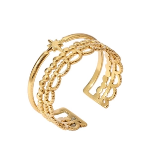 Detail of layered 18k gold plated multi-band ring with star motifs and wave patterns