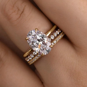 Nahaufnahme eines dreiteiligen Goldring-Sets mit ovalem Hauptstein und Pavé-Besatz