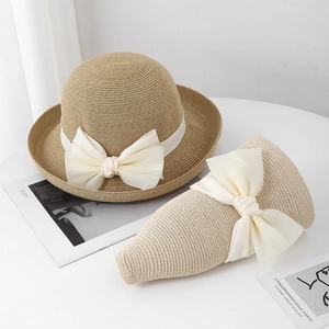 Elegante strooien zonnehoed voor dames met grote crème strik ideaal voor de vakantie.