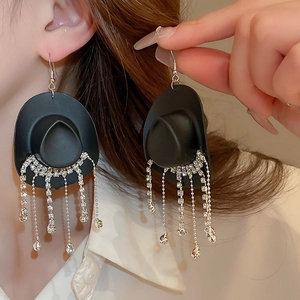 Detail view of fashion cowboy hat earrings with sparkling diamond fringe tassels on model