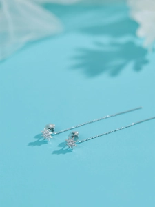 Detailed macro view of silver star tassel earrings featuring sparkling micro-pave stones