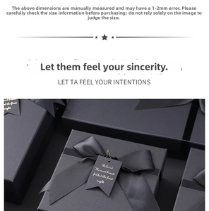 Detail of matte black gift box with silk ribbon bow and golden clip tag accessory