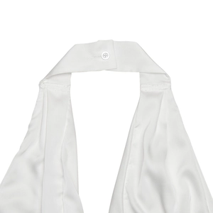 Détail d'un décolleté licou blanc élégant avec fermeture à bouton sur robe de soirée