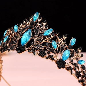 Detailed close-up of baroque bridal crown with blue crystals and antique gold metal