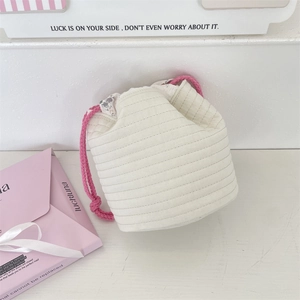 Close-up of quilted drawstring storage bag with pink floral lining and woven cord