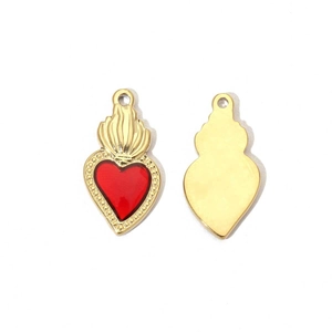 Detailed view of gold heart wing lock pendant showing front red enamel and polished back