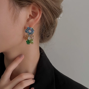 Vue détaillée de boucles d'oreilles fleurs en cristal coloré portées par un mannequin