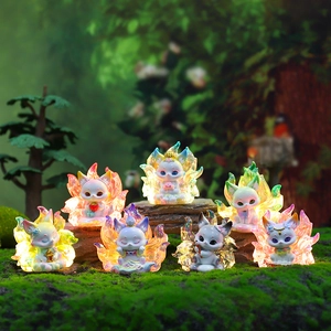Group of seven glowing translucent resin fox figurines on mossy rock display
