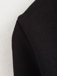 Nahaufnahme der Schulternaht und feinen Strickstruktur des schwarzen V-Ausschnitt-Cardigans