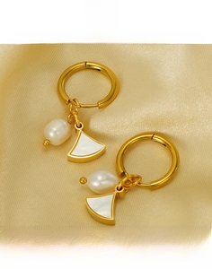 Gros plan de boucles d'oreilles en éventail nacré avec détails de perles blanches