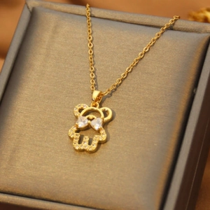 Detail of bear pendant with white cubic zirconia and gold chain on jewelry box
