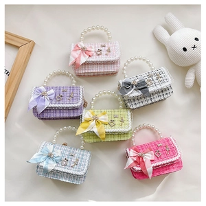 Detail of colorful plaid kids bags with faux pearl handles and sweet bow decorations