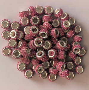 Close-up of pink crystal-encrusted eyelet beads for DIY jewelry making and bracelet crafts