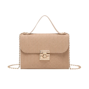 Detail view of beige crossbody bag with herringbone embossing and gold chain strap
