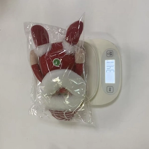 Detailed view showing the weight of a Christmas plush ornament on a digital scale