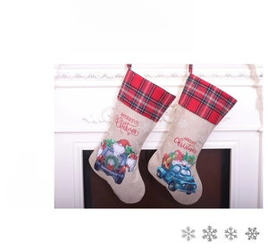 Detail view of burlap Christmas stockings featuring Santa gnomes and a blue truck pattern