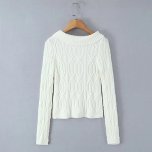 Detailed close-up of white cable knit texture on a soft long-sleeve sweater