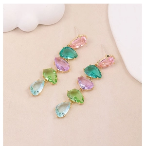 Macro detail of drop-shaped colorful zircons and gold-plated long tassel earrings