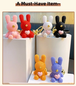 Detailed close-up of six colorful resin rabbit keychains with knitted texture and gold bells