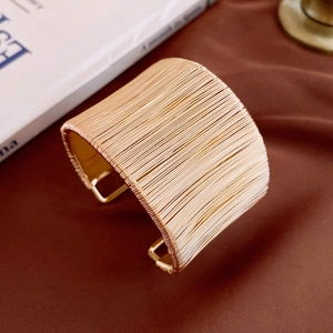 Vue détaillée du bracelet jonc doré à fils multiples torsadés sur tissu en soie