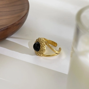 French vintage 18K gold stainless steel ring with round black gemstone on white surface