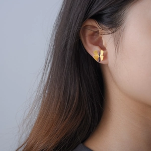 Elegant gold butterfly S925 silver stud earrings worn by model on a grey background